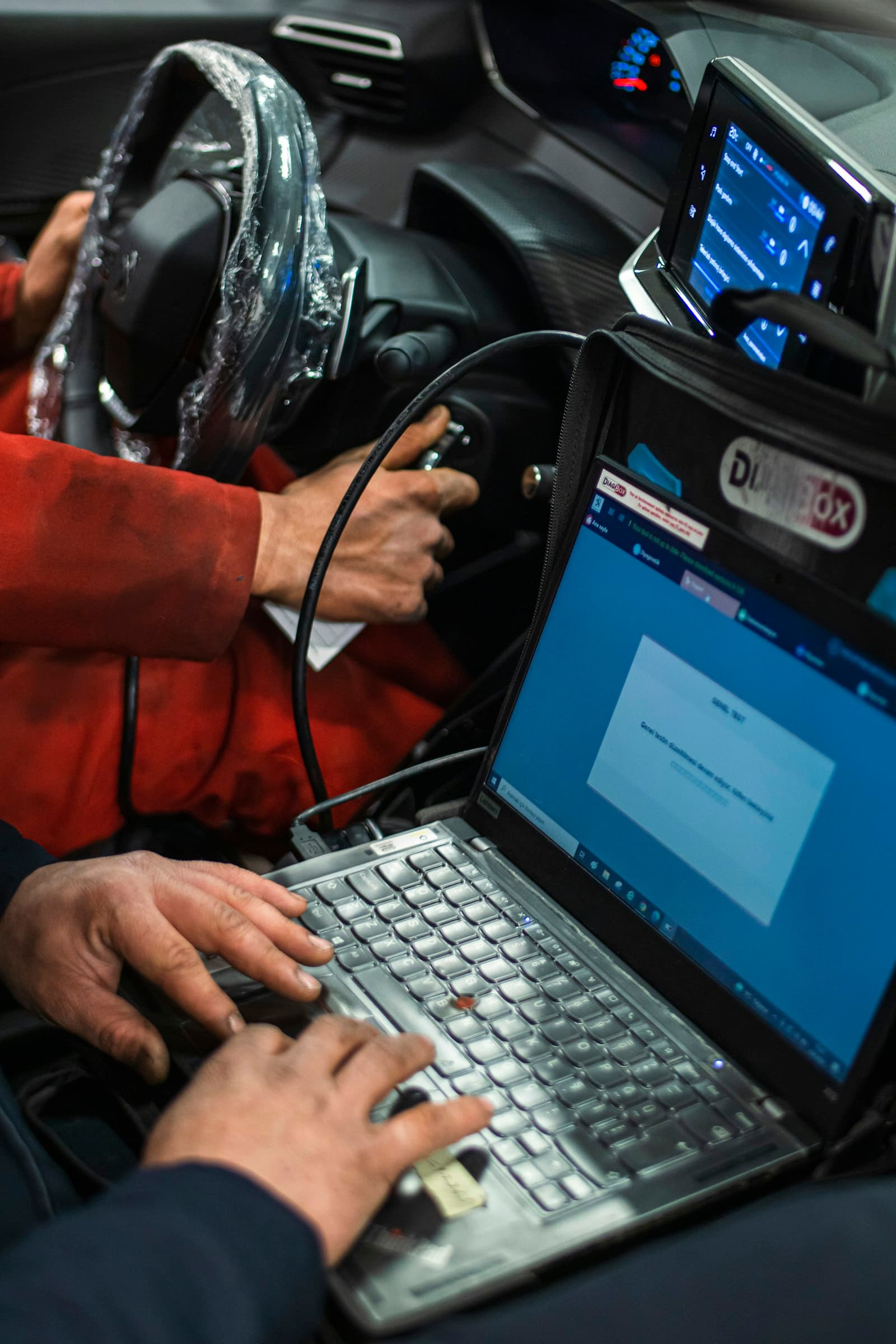 A laptop-based diagnostic scan tool connected to a vehicle