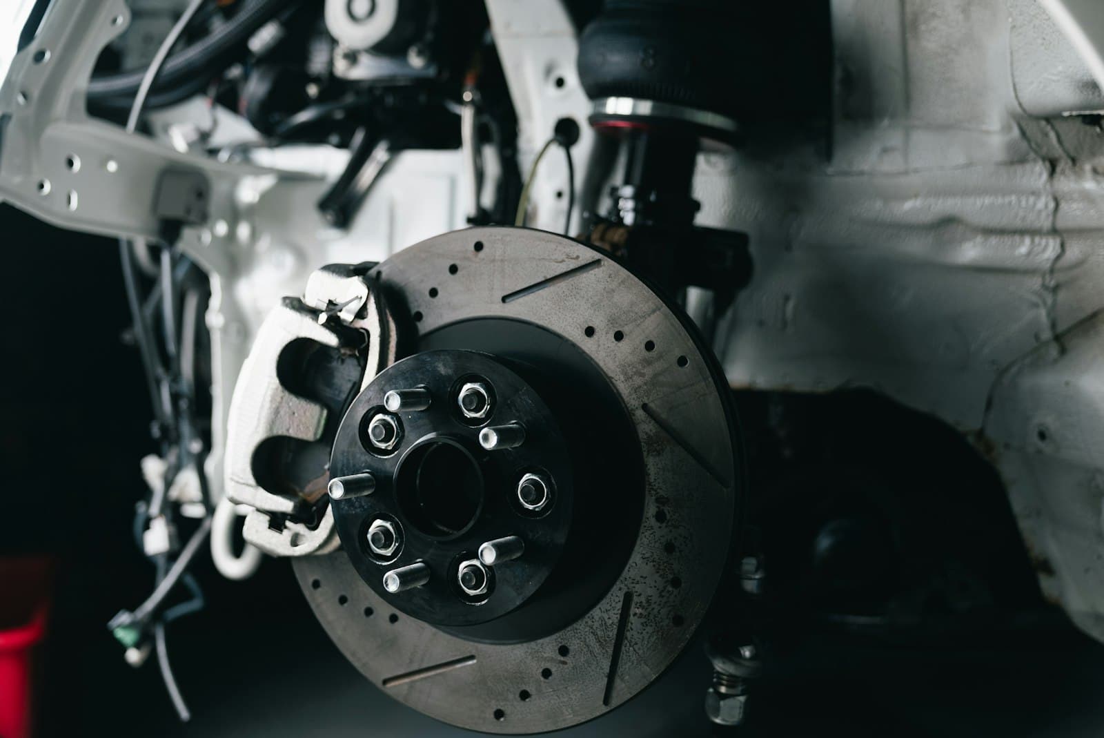 A brake rotor and caliper exposed with the wheel removed from the vehicle