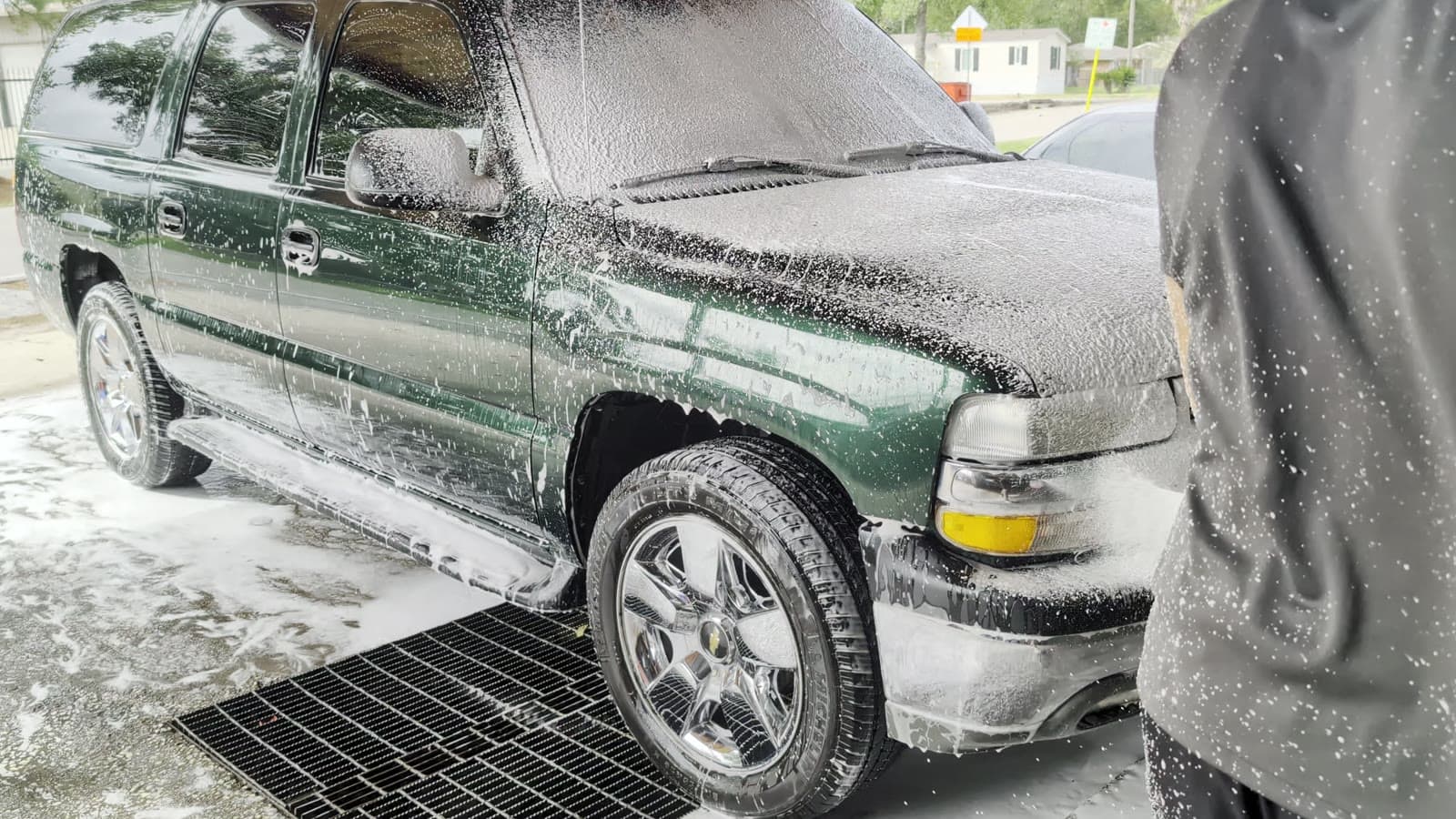 A car wheel and fender being washed with soapy water