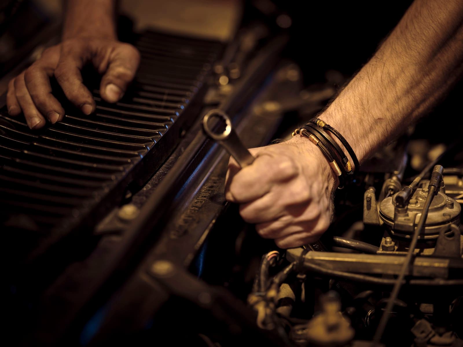 A technician using a wrench on an engine